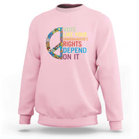Light pink crewneck graphic sweatshirt with floral peace sign and voting text design