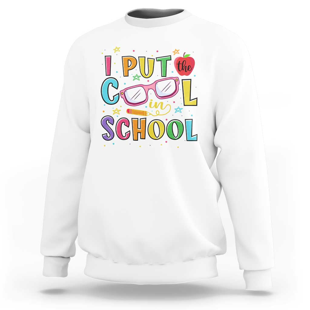 White sweatshirt with colorful school-themed graphic and glasses-and-pencil design