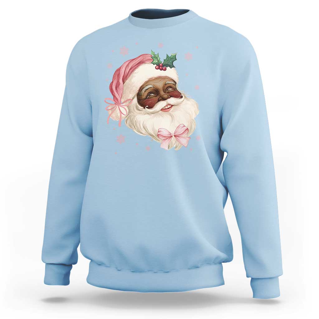 Light blue crewneck sweatshirt with cartoon Santa face and pink bow graphic on chest