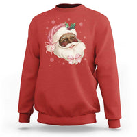 Red crewneck sweatshirt with cartoon Santa face and pink bow graphic on chest