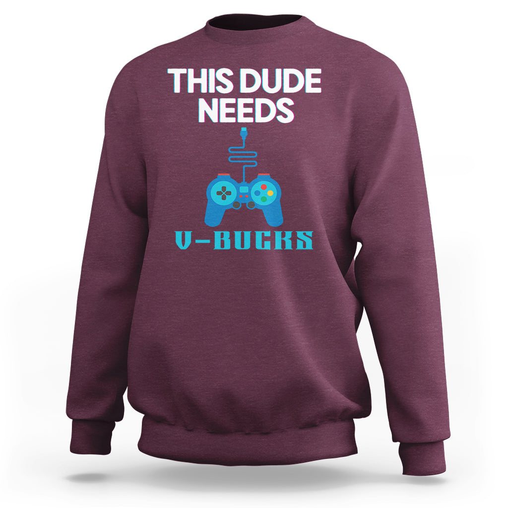 Maroon crewneck sweatshirt with “THIS DUDE NEEDS” gaming controller graphic and V-BUCKS text