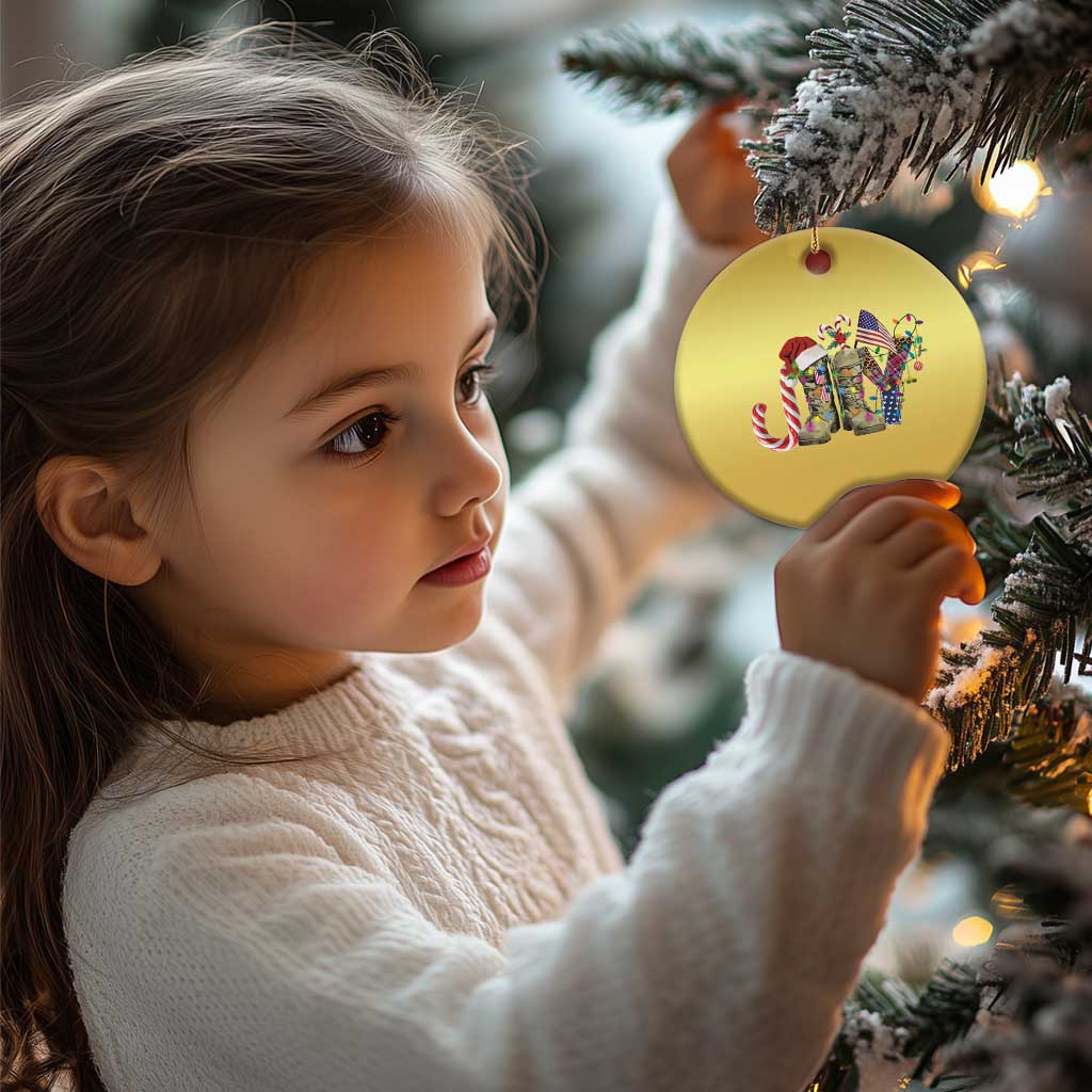 Gold round Christmas ornament with veterans graphic, held by a child