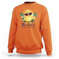 Orange sweatshirt with cartoon chick graphic and 'This chick is retired' print.