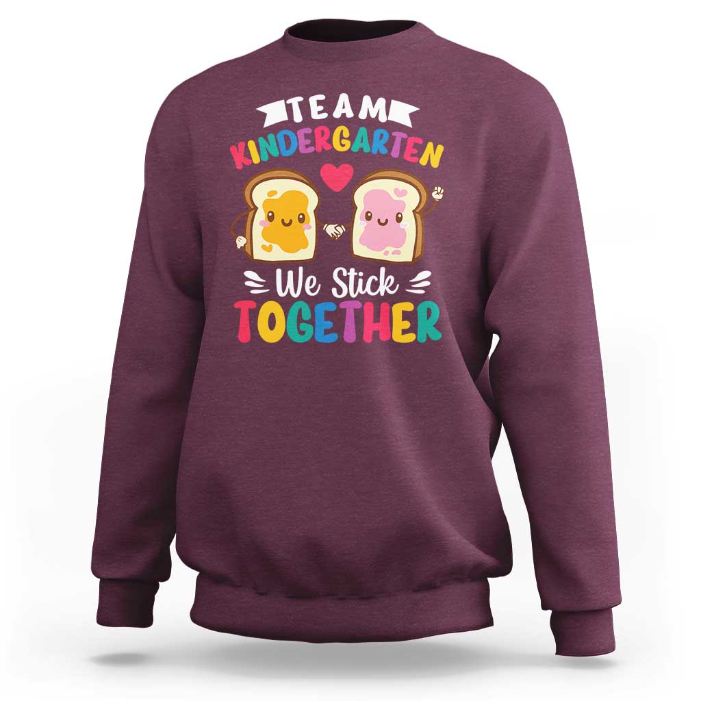 Maroon kids sweatshirt with back graphic 'We Stick Together' and 'Team Kindergarten'.