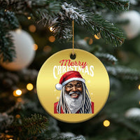 Gold circular “Merry Christmas” Santa ornament hanging from pine branches