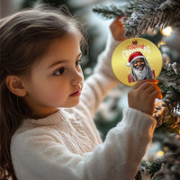 Gold circular Santa Christmas ornament on a tree, partially visible near a child