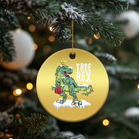 Gold round hanging ornament featuring Tree Rex dinosaur on snowy ground and star charm