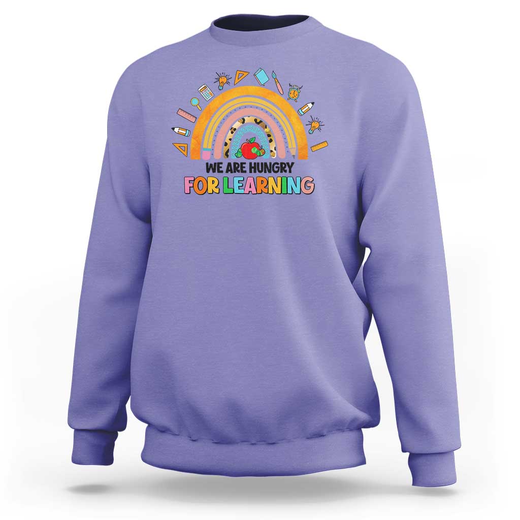 Violet crewneck sweatshirt with rainbow and “We are hungry for learning” graphic