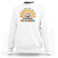 White crewneck sweatshirt with rainbow and “We are hungry for learning” graphic