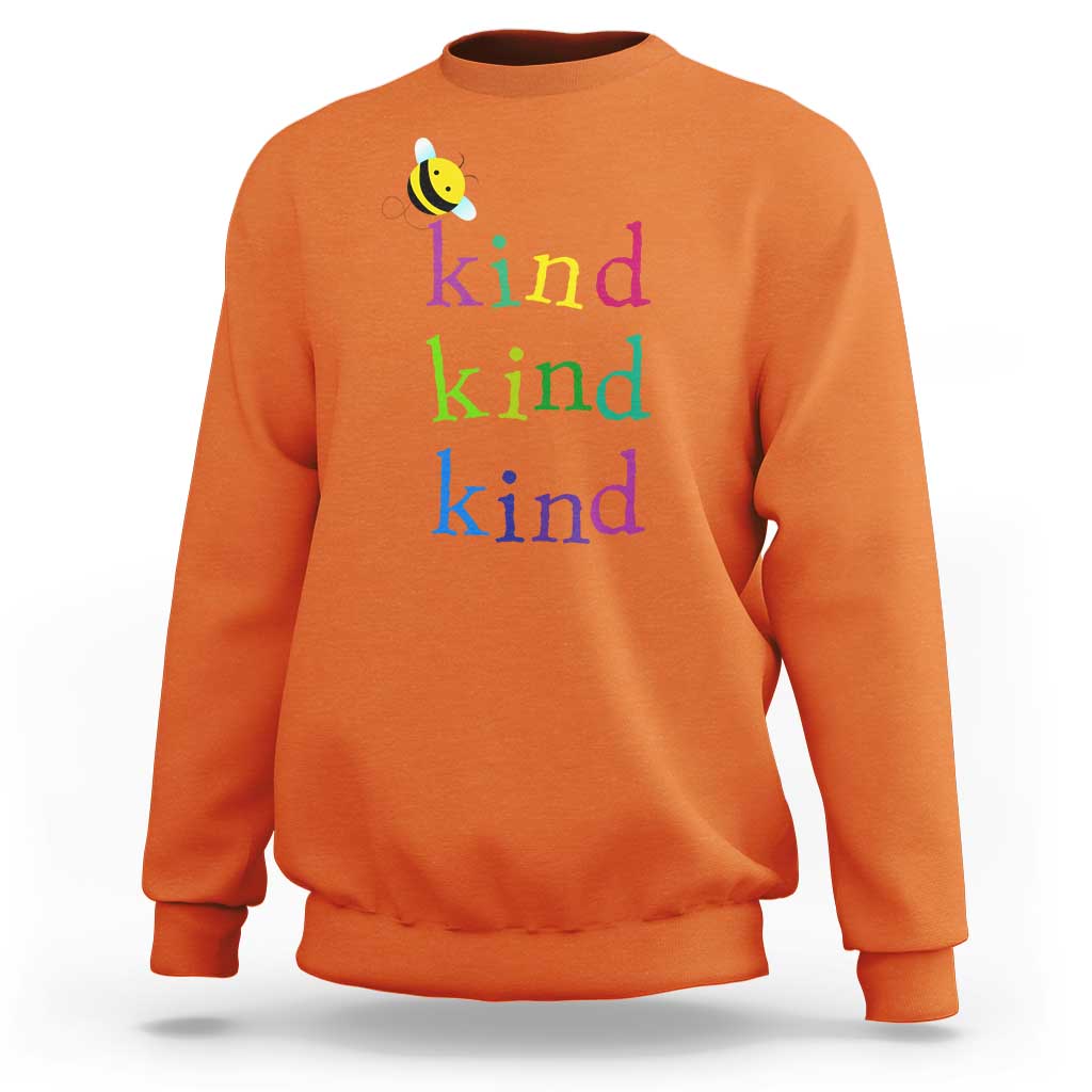 Orange crewneck sweatshirt with small bee and rainbow 'kind kind kind' print.