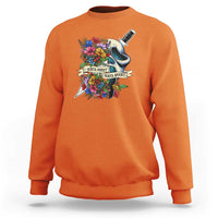 Orange sweatshirt with floral ghost and knife graphic on the chest