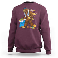 Men's crewneck sweatshirt in maroon with Hanukkah Bigfoot menorah graphic