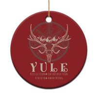 Red round Christmas ornament with gold hanging string and antlered skull emblem.