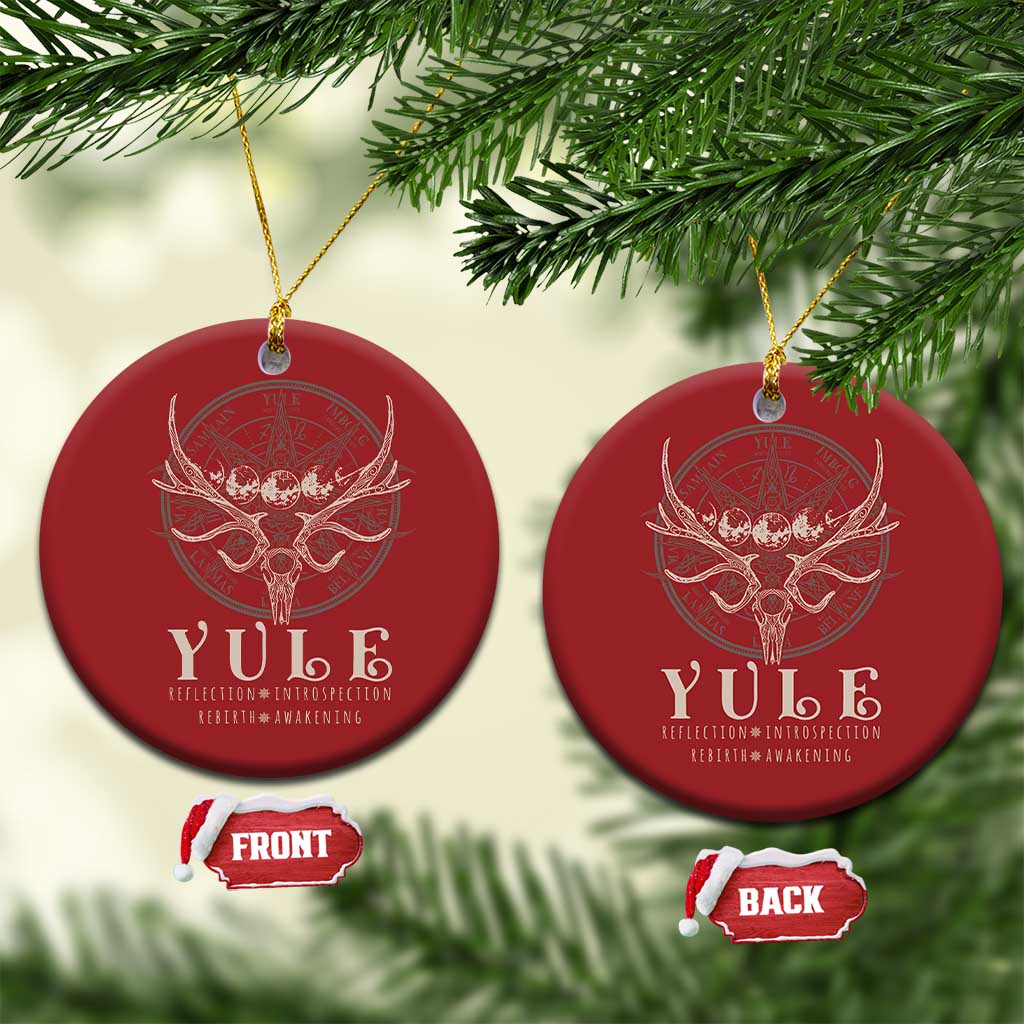 Set of red round Christmas ornaments with gold hanging strings and antlered skull emblem.