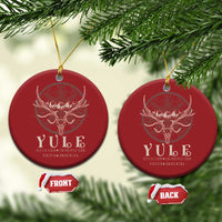Set of red round Christmas ornaments with gold hanging strings and antlered skull emblem.