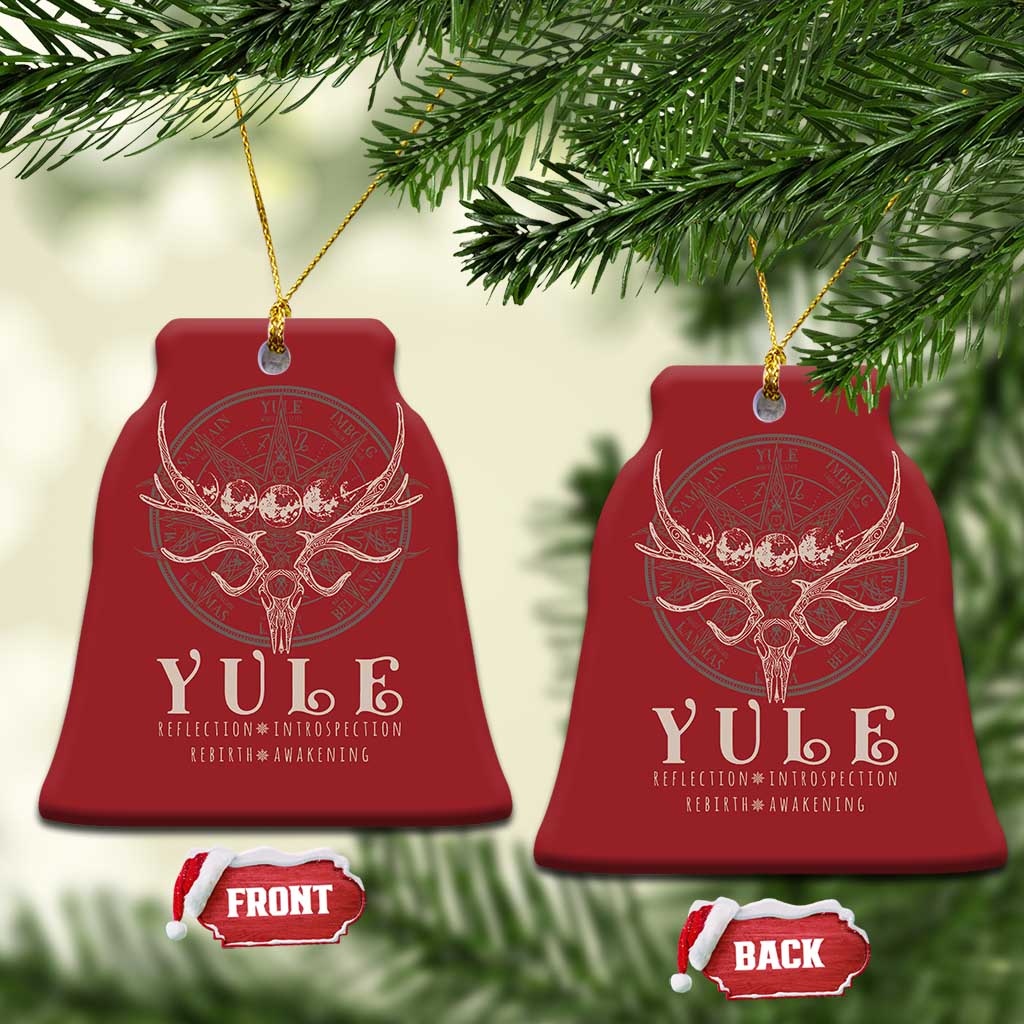 Red bell-shaped Christmas ornaments with gold hanging strings and antlered skull emblem.