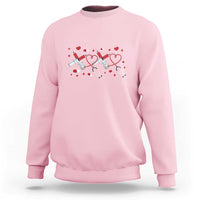 Light pink crewneck sweatshirt with red heart stethoscope graphic on the front