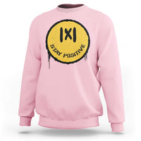 Light pink crewneck sweatshirt with yellow “IXI” “Stay Positive” graphic on the chest