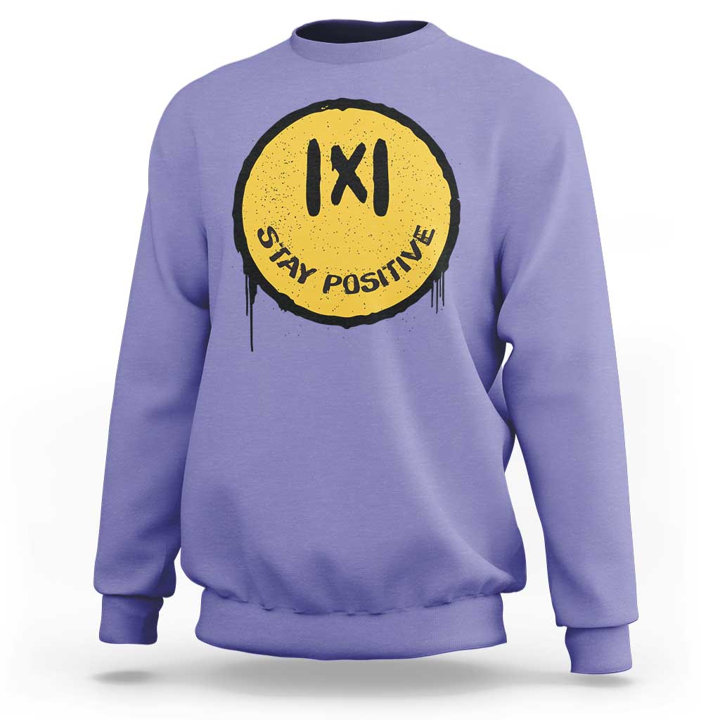 Violet crewneck sweatshirt with yellow “IXI” “Stay Positive” graphic on the chest