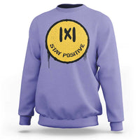 Violet crewneck sweatshirt with yellow “IXI” “Stay Positive” graphic on the chest