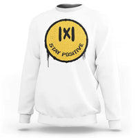 White crewneck sweatshirt with yellow “IXI” “Stay Positive” graphic on the chest