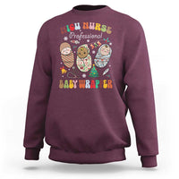 Maroon sweatshirt with NICU Nurse Professional Baby Wrapper graphic and cartoon characters