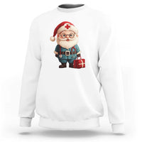 White crewneck sweatshirt with Santa doctor graphic and red cross medicine badge