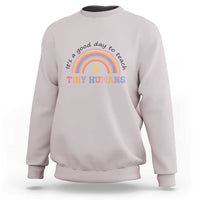 Light gray sweatshirt with rainbow arc and heart graphic reading "Tiny Humans"