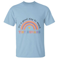 Light blue teacher T-shirt with rainbow heart graphic and “Tiny Humans” text