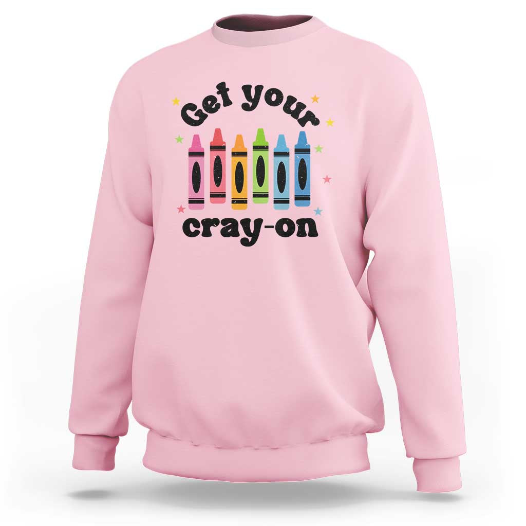 Light pink sweatshirt with front “Get Your Cray-on” text and colorful crayon graphic