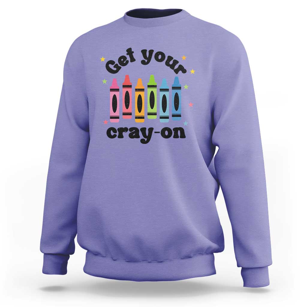 Violet sweatshirt with front “Get Your Cray-on” text and colorful crayon graphic