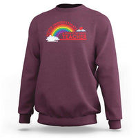 Maroon crewneck sweatshirt with “Never Underestimate” rainbow teacher graphic on chest