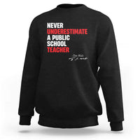 Black crewneck sweatshirt with centered "Never Underestimate" teacher graphic