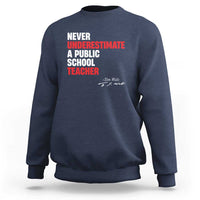 Royal blue crewneck sweatshirt with centered "Never Underestimate" teacher graphic