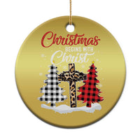 Gold round Christmas ornament with red “Christmas begins with Christ” and plaid cross scene