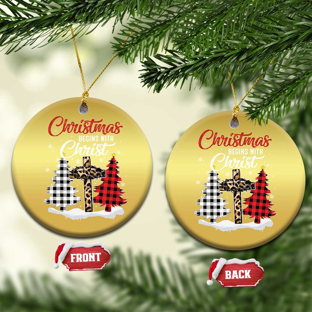 Two gold round Christmas ornaments on a tree, “Christmas begins with Christ” plaid cross graphic