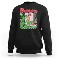 Black crewneck sweatshirt with colorful “Christmas on Off Season” skeleton hand graphic