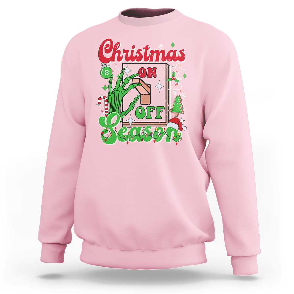 Light pink crewneck sweatshirt with colorful “Christmas on Off Season” skeleton hand graphic