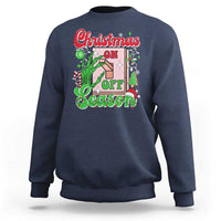 Navy crewneck sweatshirt with colorful “Christmas on Off Season” skeleton hand graphic