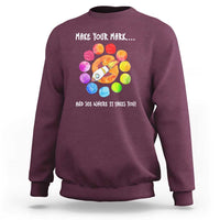Maroon crewneck sweatshirt with colorful dot rocket graphic on the back