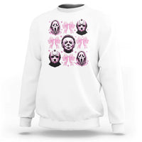 White sweatshirt with pink bow graphic featuring skull faces on the front