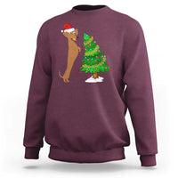 Maroon wiener dog Christmas sweatshirt with Santa hat and decorated Christmas tree graphic