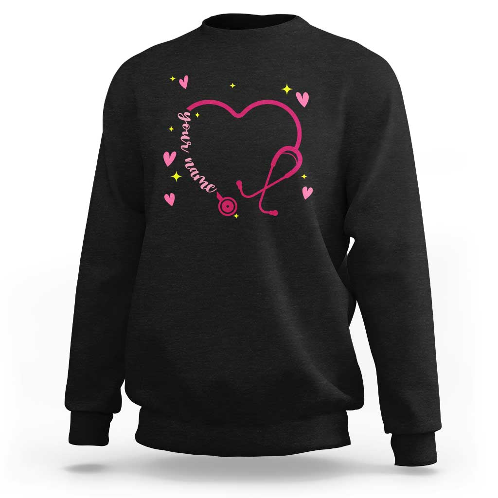 Black crewneck sweatshirt with pink heart stethoscope graphic and small colorful hearts