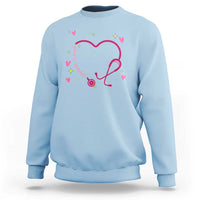 Light blue crewneck sweatshirt with pink heart stethoscope graphic and small colorful hearts