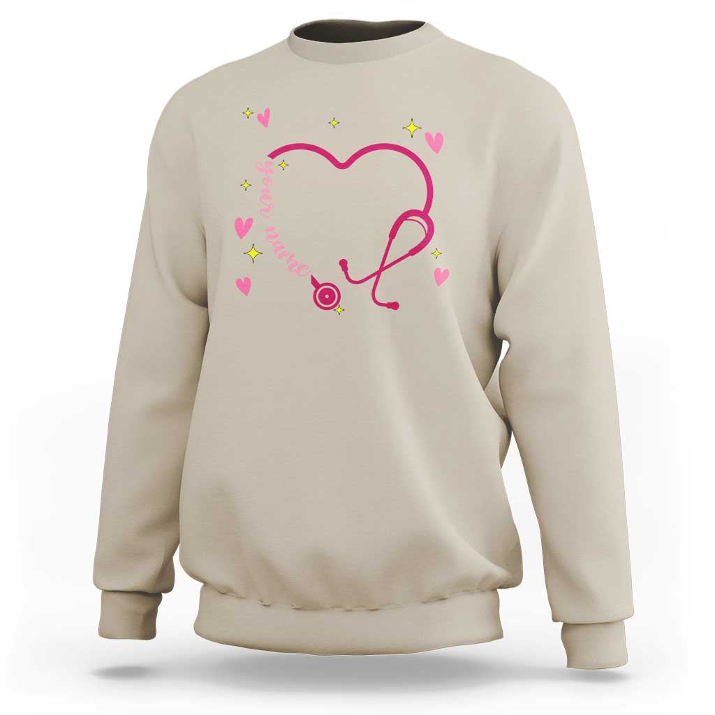 Sand crewneck sweatshirt with pink heart stethoscope graphic and colorful heart accents