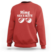 Red sweatshirt with “Ring Security” print and sunglasses graphic on front.