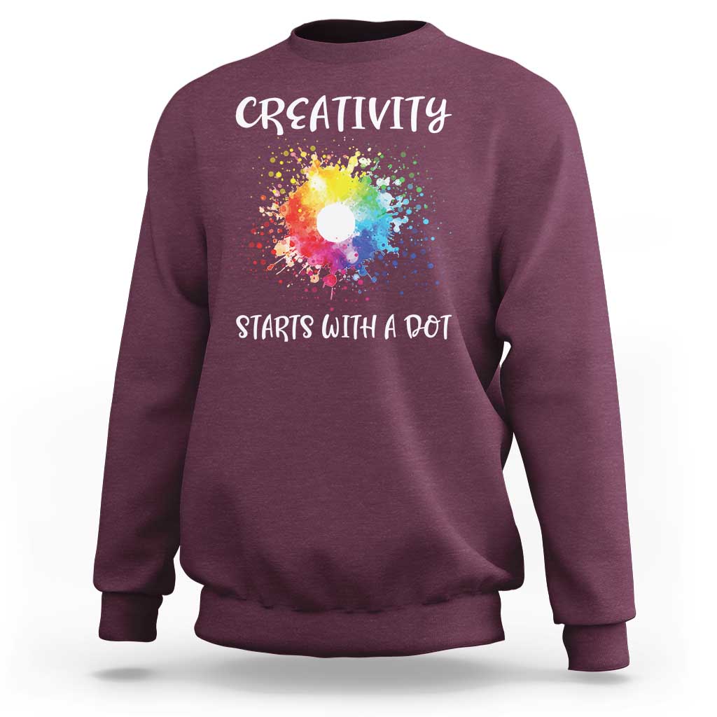 Maroon crewneck sweatshirt with colorful dot graphic and “CREATIVITY STARTS WITH A DOT” text