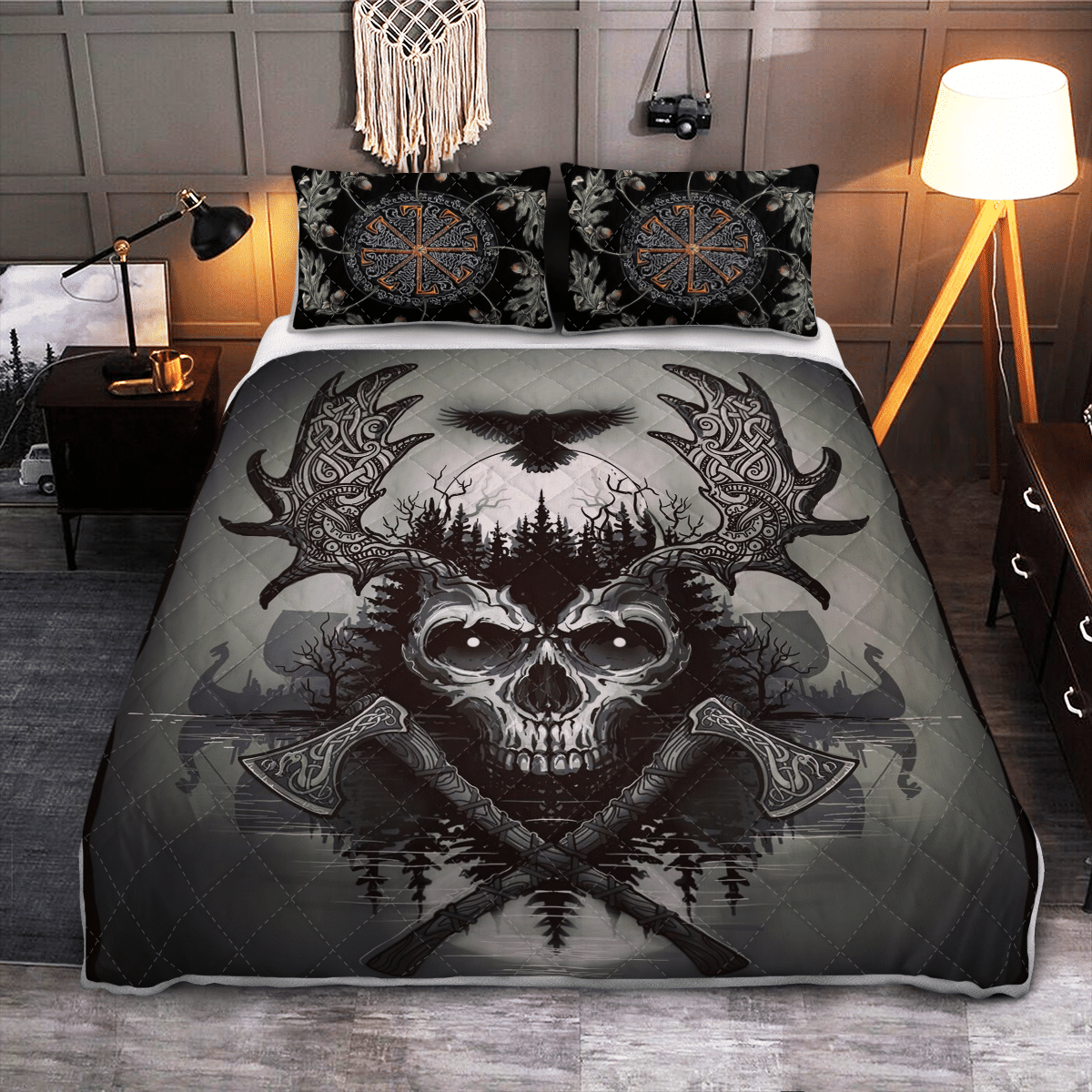Black quilt bed set with raven and skull graphic, flanked by patterned pillowcases