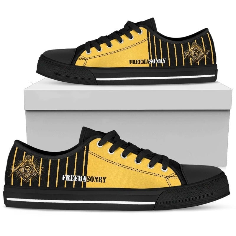 Yellow low-top sneaker with black laces, black toe cap, gold Freemasonry logo