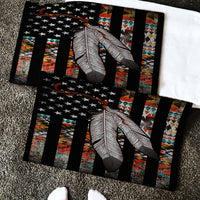 Close-up flag feather doormat: black bars, gray feather, multicolor geometric accents